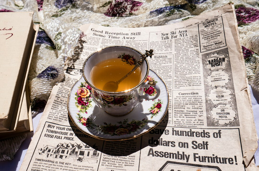 Stack of old newspapers with a coffee cup